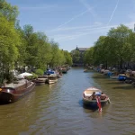 Un canal bordé d'arbres et de péniches dans le centre d'Amsterdam