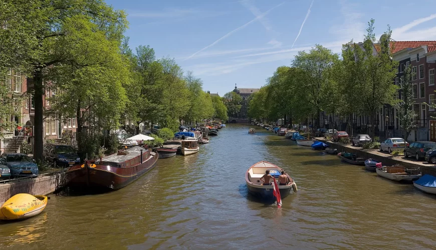Un canal bordé d'arbres et de péniches dans le centre d'Amsterdam