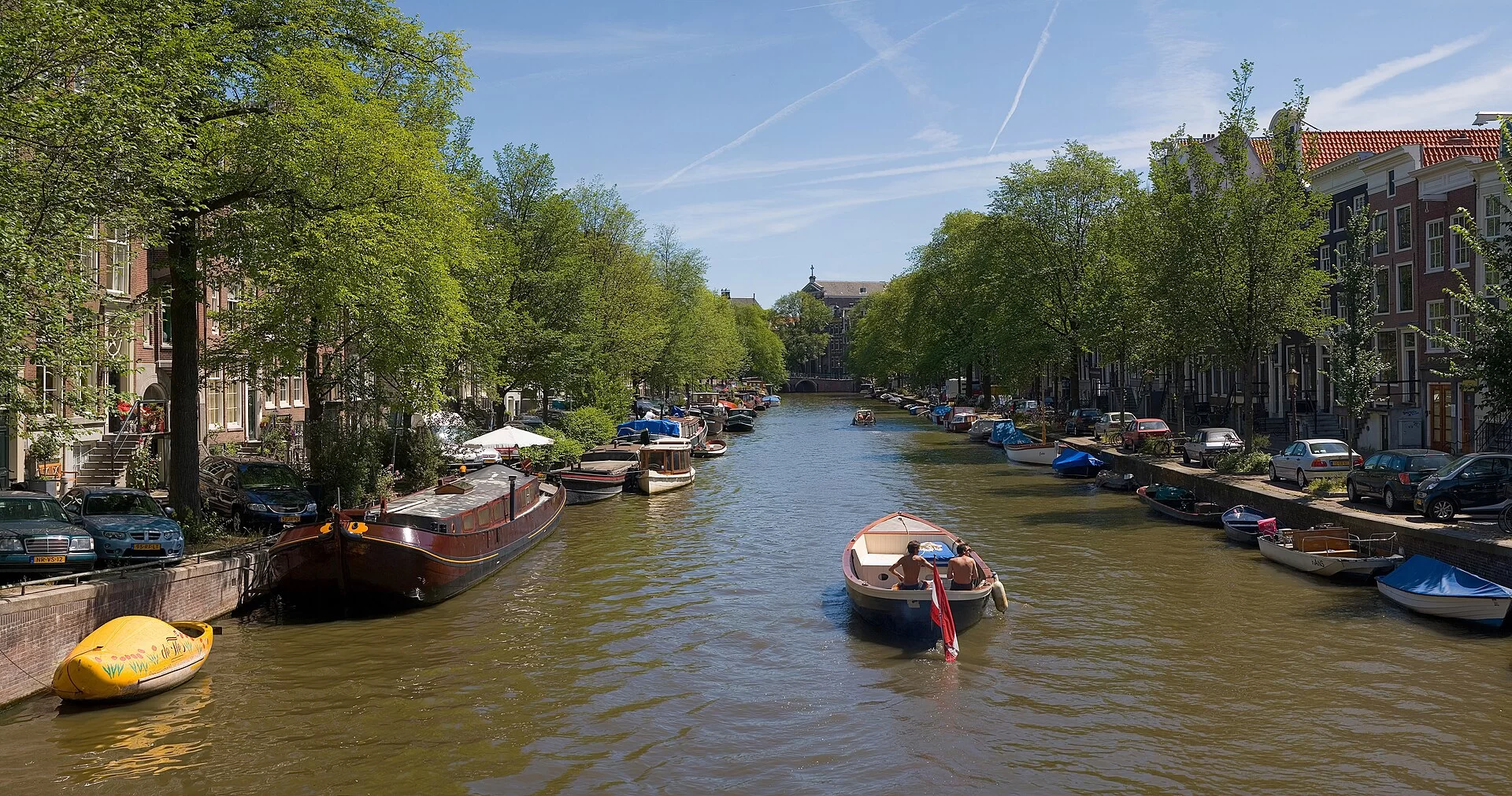Un canal bordé d'arbres et de péniches dans le centre d'Amsterdam