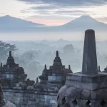 Les stupas de Borobudur dans la brume avec les volcans en arrière-plan, à Java, en Indonésie