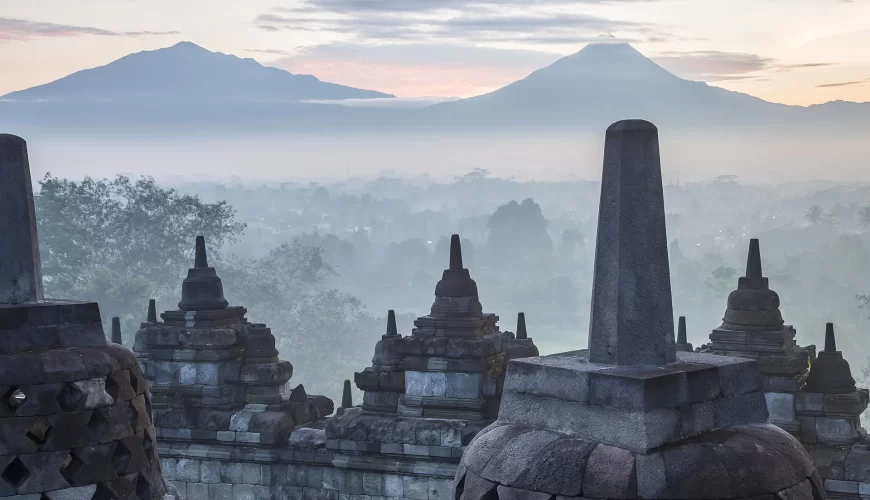 Les stupas de Borobudur dans la brume avec les volcans en arrière-plan, à Java, en Indonésie