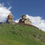 L'église de la Trinité de Gergeti sur sa colline verte, en Géorgie
