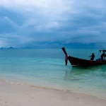 Un bateau longtail sur une plage de sable blanc près de Phuket