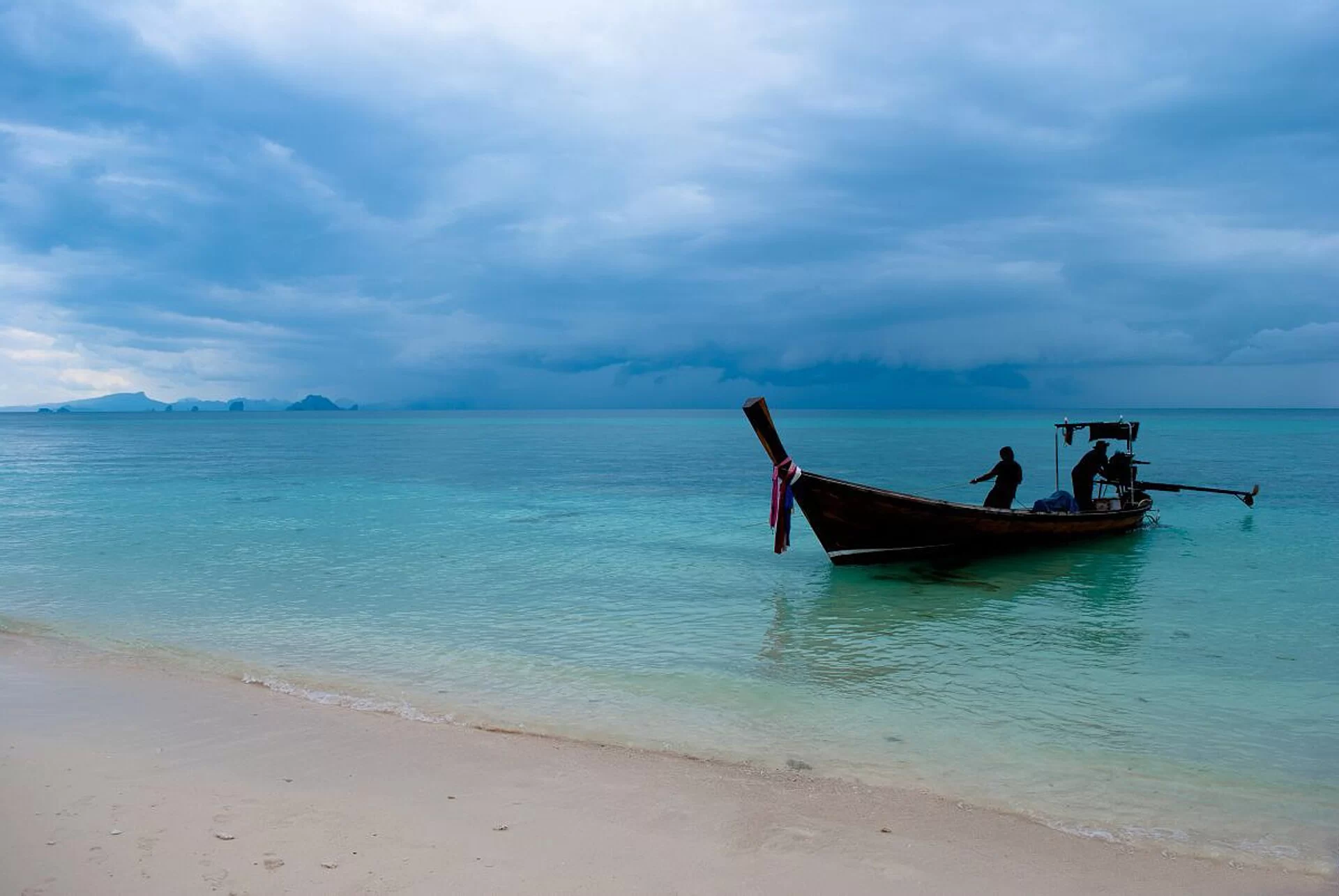 Un bateau longtail sur une plage de sable blanc près de Phuket