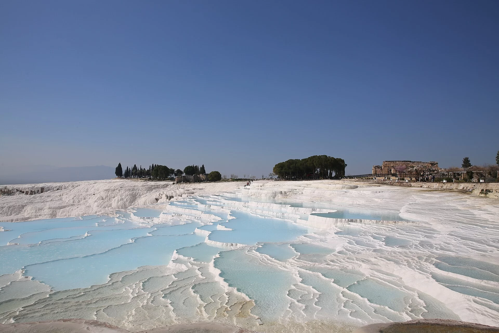 Les terrasses de travertin blanc de Pamukkale sous un ciel bleu en Turquie