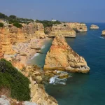 La plage de Marinha encadrée de falaises ocre en Algarve