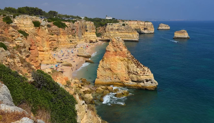 La plage de Marinha encadrée de falaises ocre en Algarve