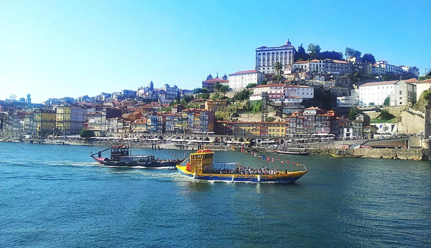 Des bateaux rabelos sur le Douro devant la colline de Porto